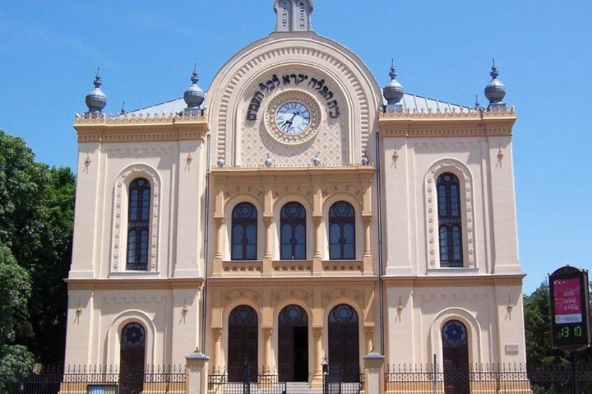 A large, ornate building with a clock tower, arched windows, and decorative elements. 3