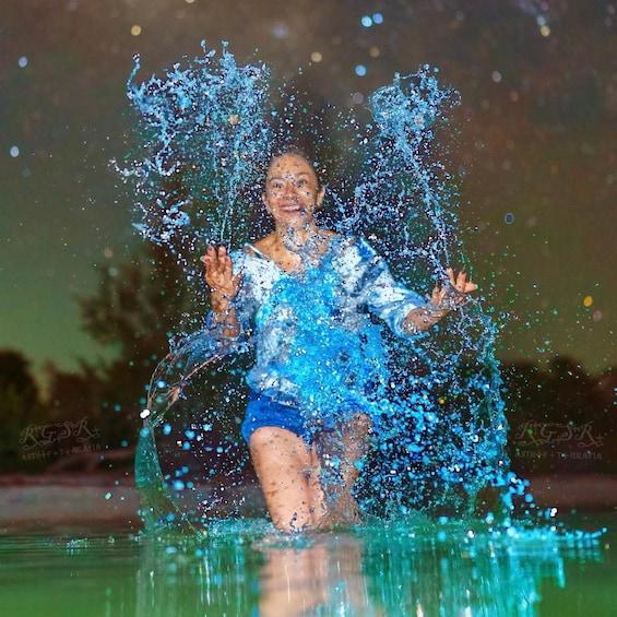 A person in a blue swimsuit splashing water. 4