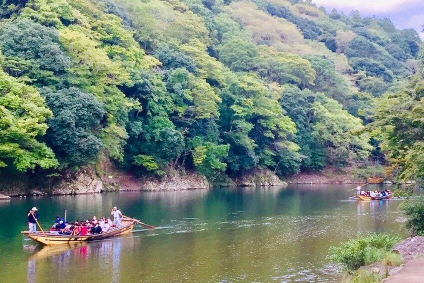 A river with boats, surrounded by dense green forest. 2