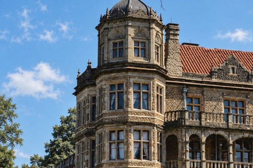 A historic building with ornate architecture, including a turret and arched windows. 2