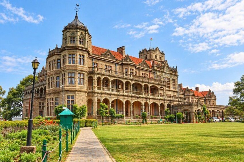 A historic building with ornate architecture, a well-maintained lawn, and a clear sky. 4