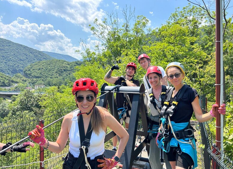 A group of people on a zip-lining course with a mountainous landscape in the background. 4