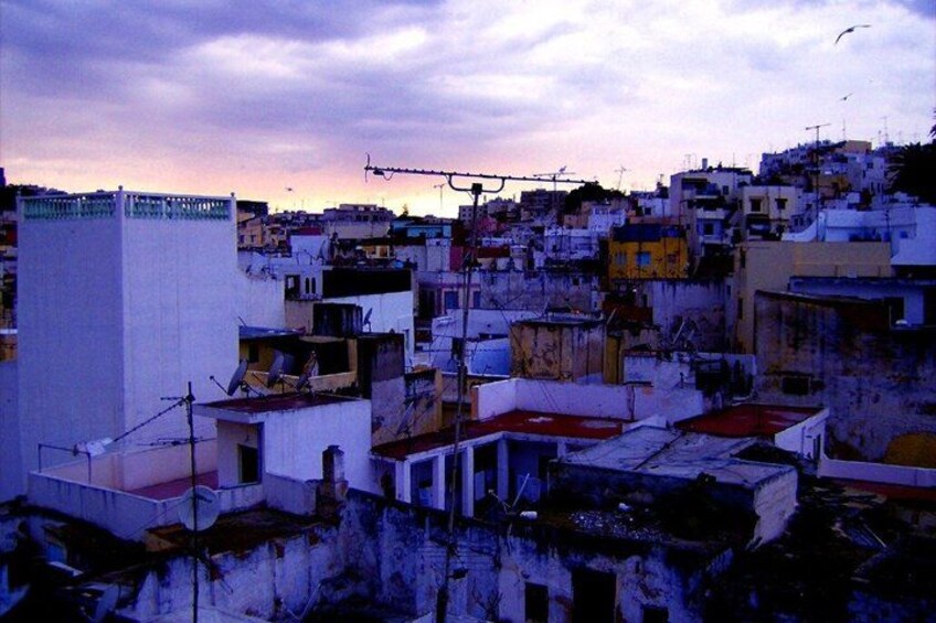 A densely packed urban area with buildings and rooftops under a dusky sky. 4
