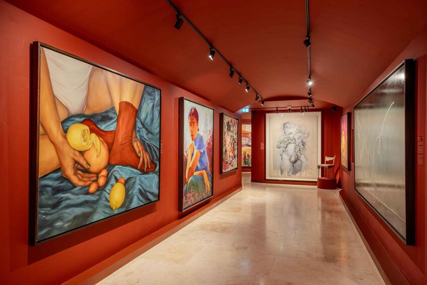 An art gallery with large paintings on the walls and a polished floor. 4