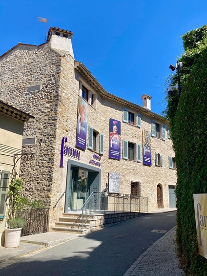 A stone building with a sign reading 'FAMM' and multiple banners. 1