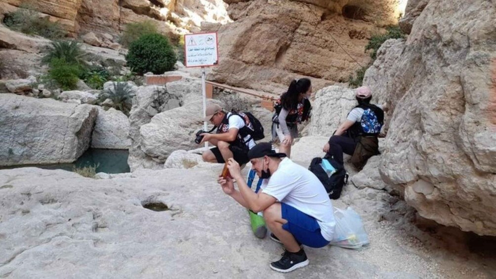 Un grupo de excursionistas en un cañón rocoso con un indicador. 4