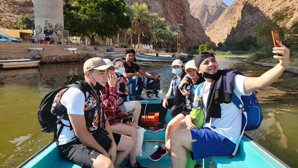A group of people on a boat in a river with mountains in the background. 5