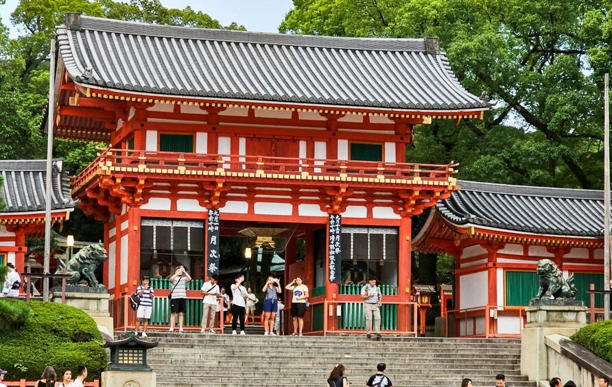 Ett traditionellt japanskt tempel med röda och vita väggar, ett tak täckt med tegelpannor och en stentrappa som leder upp till ingången. 2