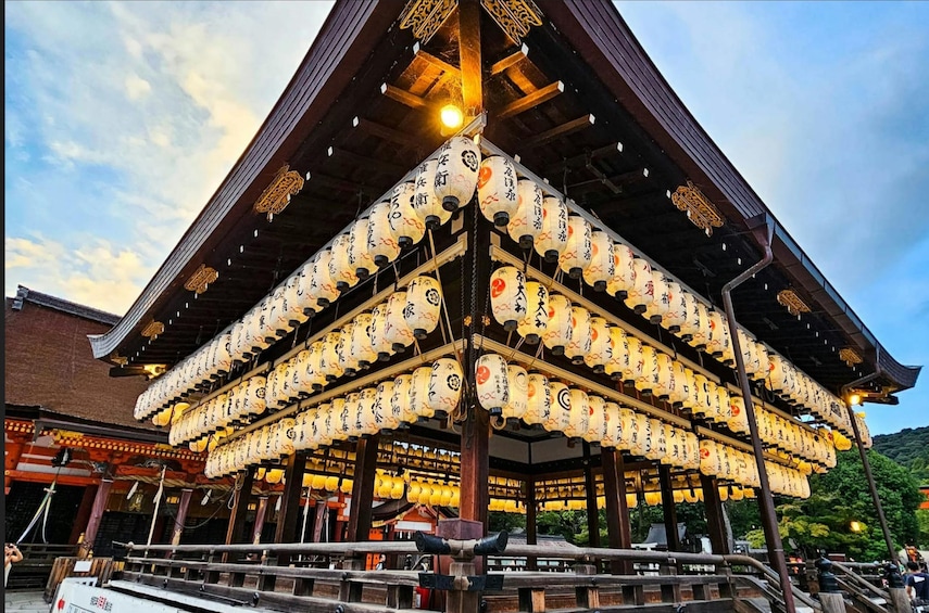En traditionell japansk byggnad med flera lyktor som hänger från taket. 1