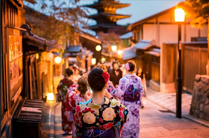 En traditionell japansk gata med människor i kimonos, lyktor och ett pagodtempel. 4