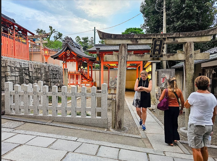 Ett traditionellt japanskt tempel med ett stengärde och besökare. 5