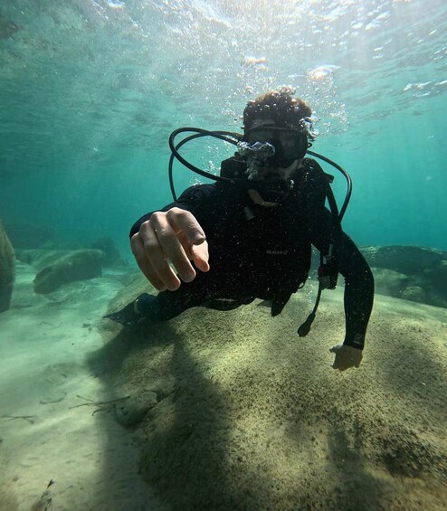 A diver underwater with bubbles, fins, and a regulator. 1