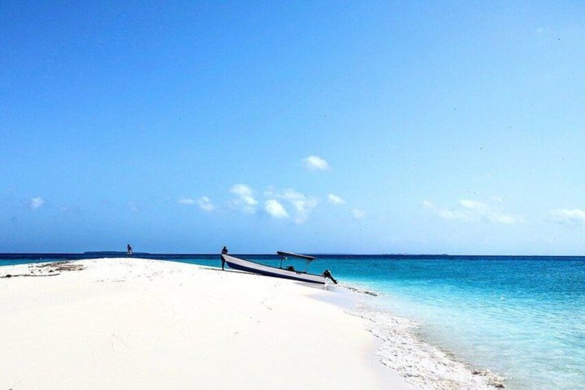 A beach with white sand and clear blue water. 2
