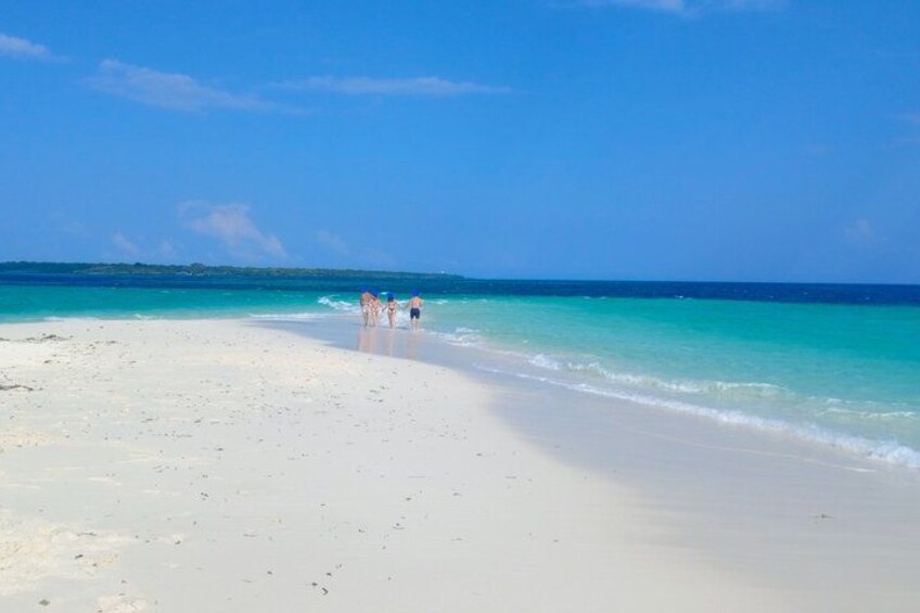 A beach with clear turquoise water and white sand. 1
