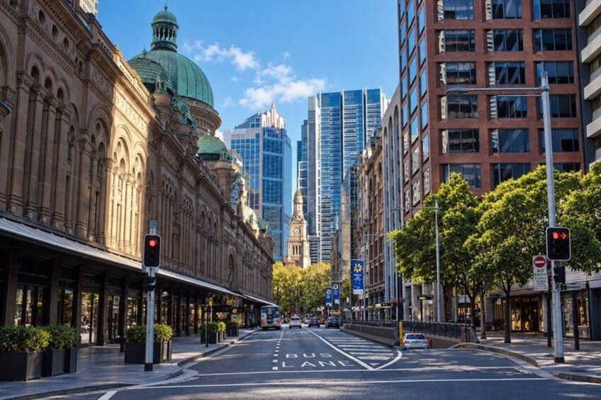 A city street with historic buildings, modern skyscrapers, and a traffic light. 3