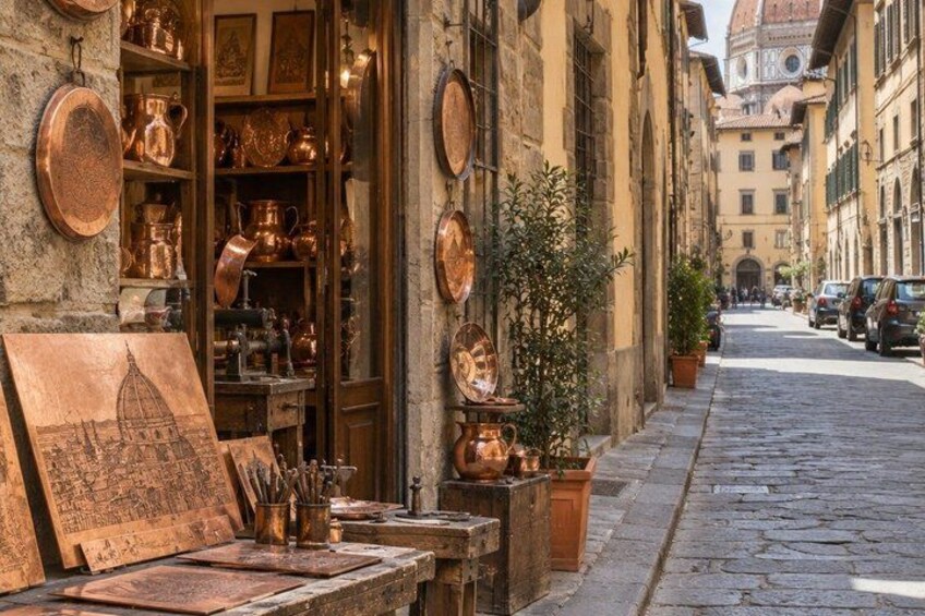 A street with a shop displaying copper items, a cobblestone road, and historic buildings in the background. 5