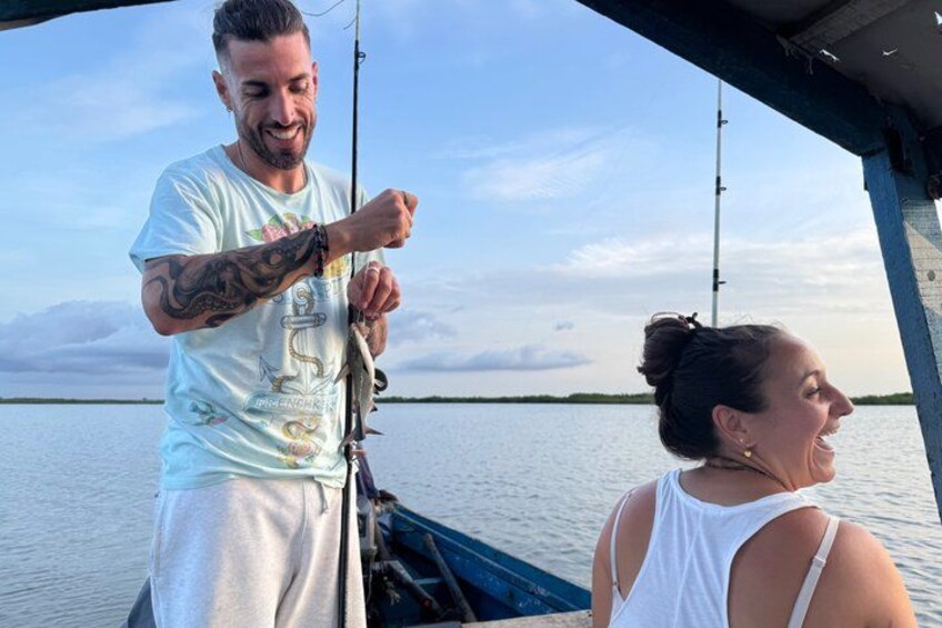 A person fishing on a boat with calm water and a clear sky. 4