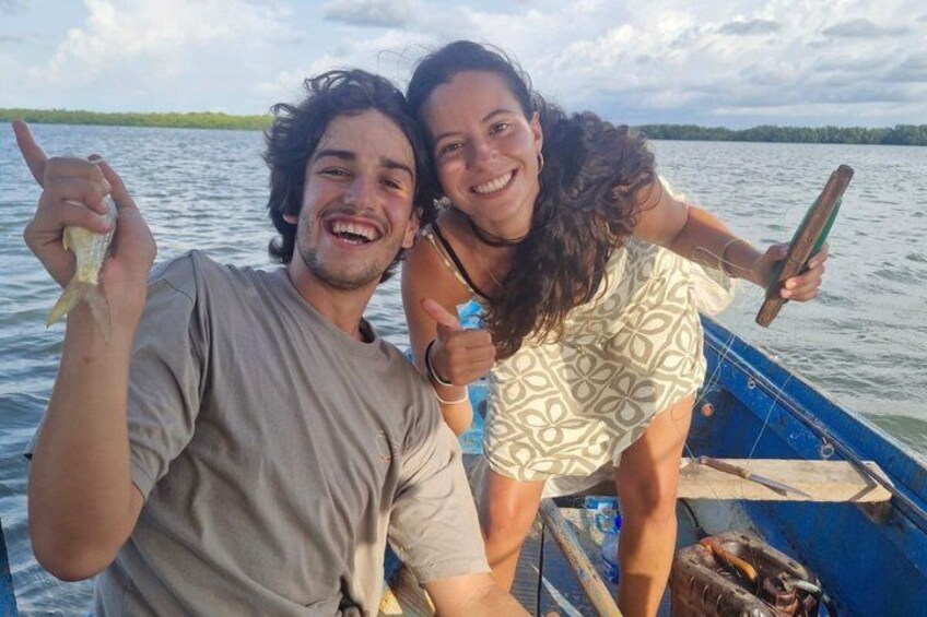 Two people on a boat holding fish. 2