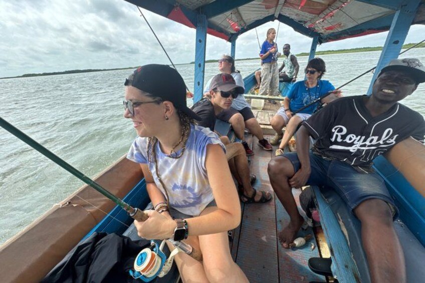 A boat with people fishing, a person wearing a 'Royals' jersey, and a calm water body in the background. 5