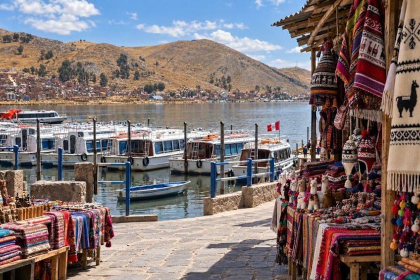 A riverside market with boats docked and colorful textiles displayed. 2