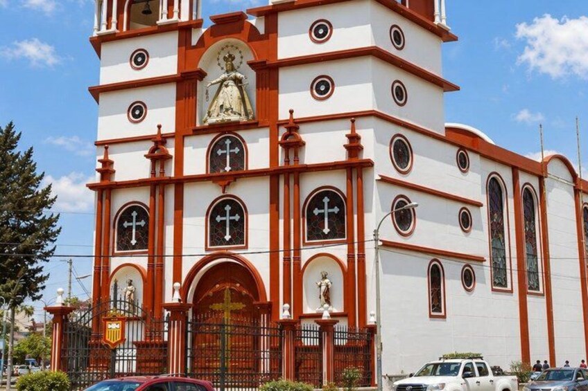 A church with a white facade, red accents, and a large central entrance. 4