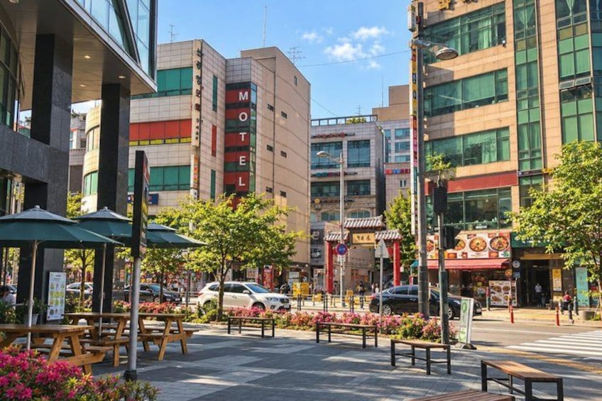 A city street with a motel, benches, and a crosswalk. 5