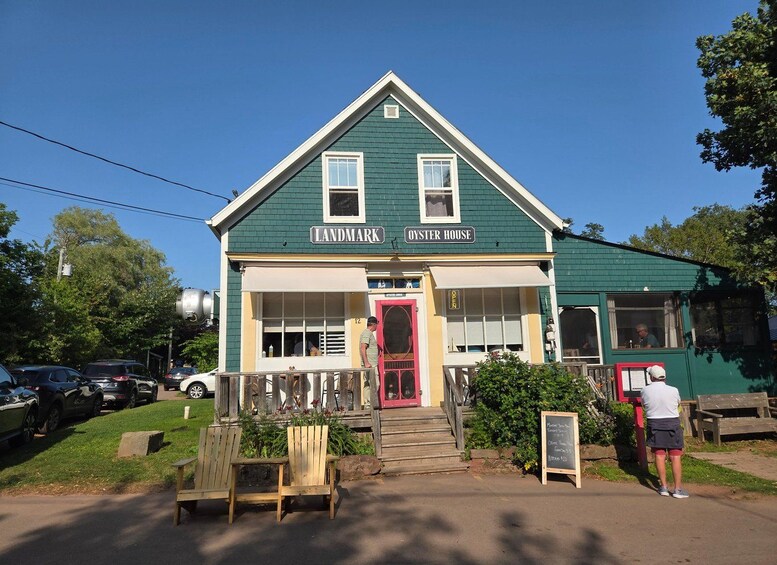 Un edificio verde con una puerta roja identificada con el rótulo 'Landmark Oyster House'. 4