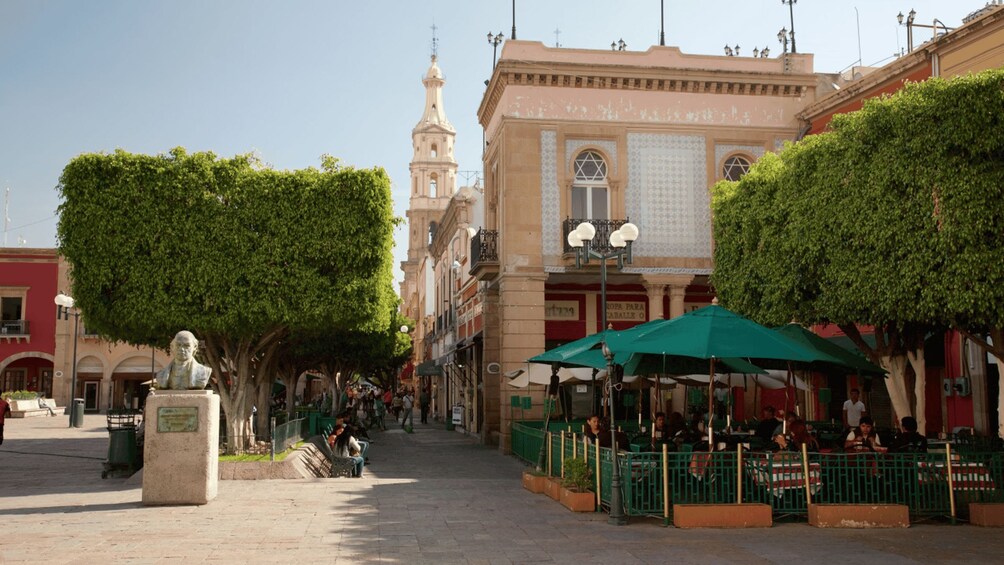 Una plaza con una estatua, una mezquita y un café con terraza. 2