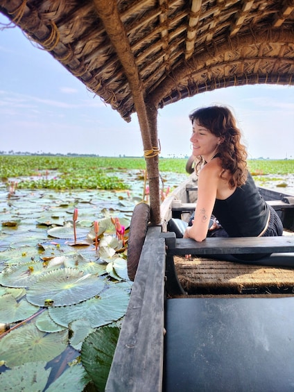 Een persoon in een boot op het water, met waterlelies en lotusbloemen. 1
