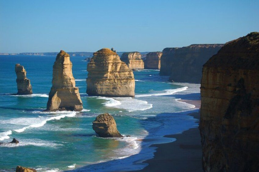 A coastal landscape with prominent rock formations and a clear blue sea. 1