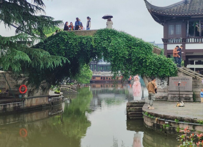 A traditional Chinese garden with a stone bridge, water, and a pagoda. 4