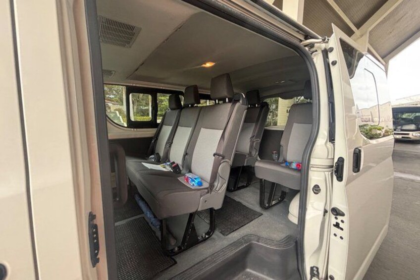 A van interior with two seats, a steering wheel, and a dashboard. 3