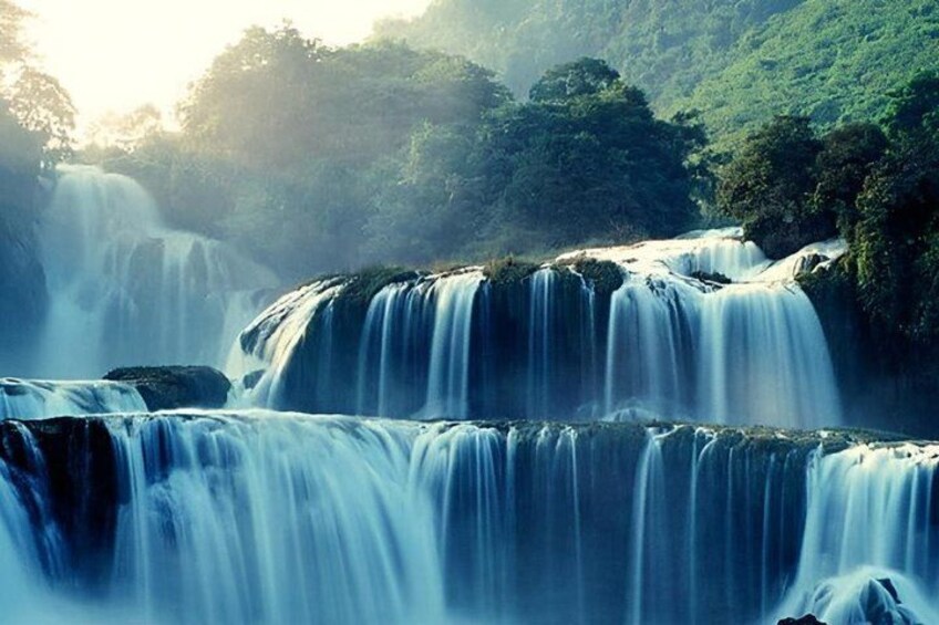 A multi-tiered waterfall surrounded by lush greenery. 2