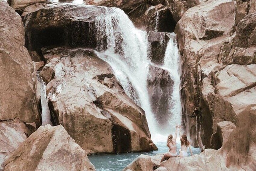 A waterfall cascading over large rocks, surrounded by a rocky landscape. 4