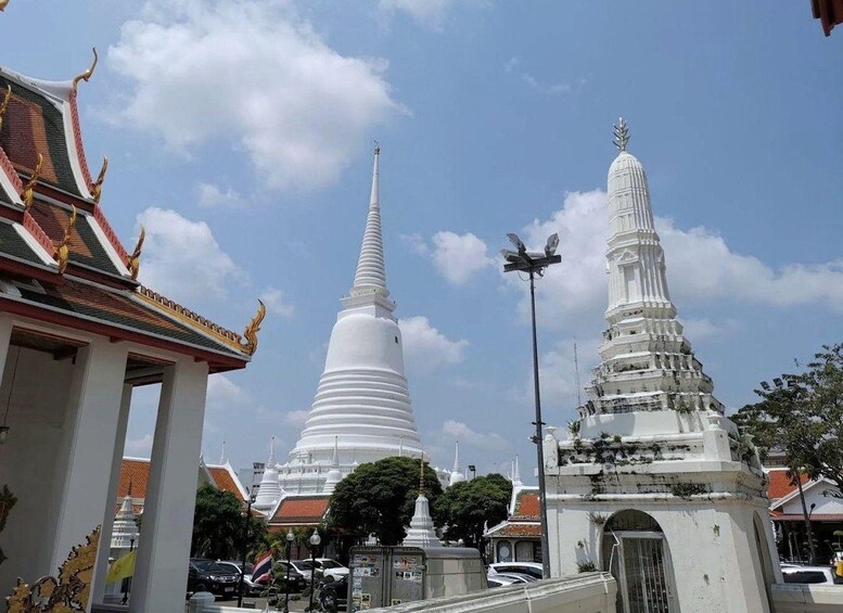 Et tempelkompleks med hvide spir og traditionel thailandsk arkitektur. 2