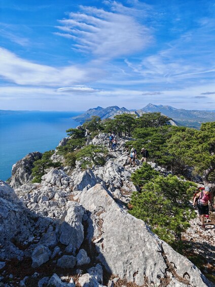 A rocky coastal landscape with hikers. 4