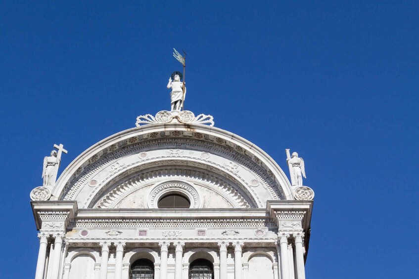 A white building with a dome and statues on top. 1