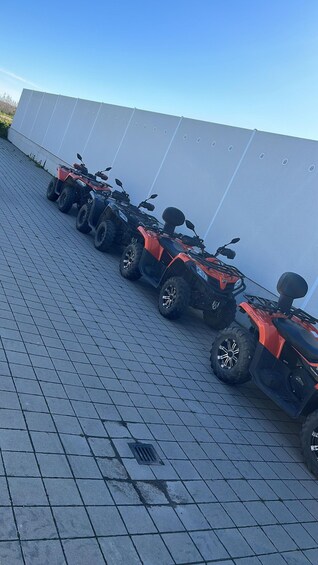 A row of ATVs parked on a tiled surface. 3