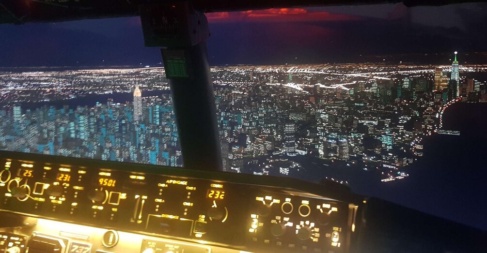 A night view from an airplane cockpit with city lights below. 2