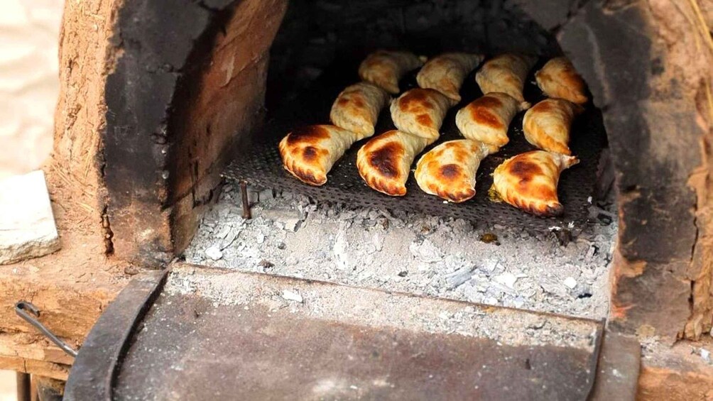 A wood-fired oven with several pastries baking inside. 1