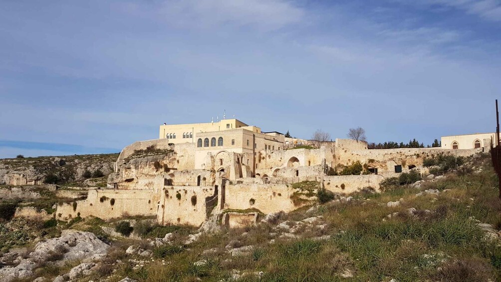 A historic stone fortress with multiple arches and a flat-roofed building. 2