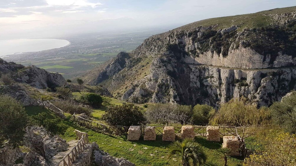 A mountainous landscape with a clear view of a valley and a body of water in the distance. 3
