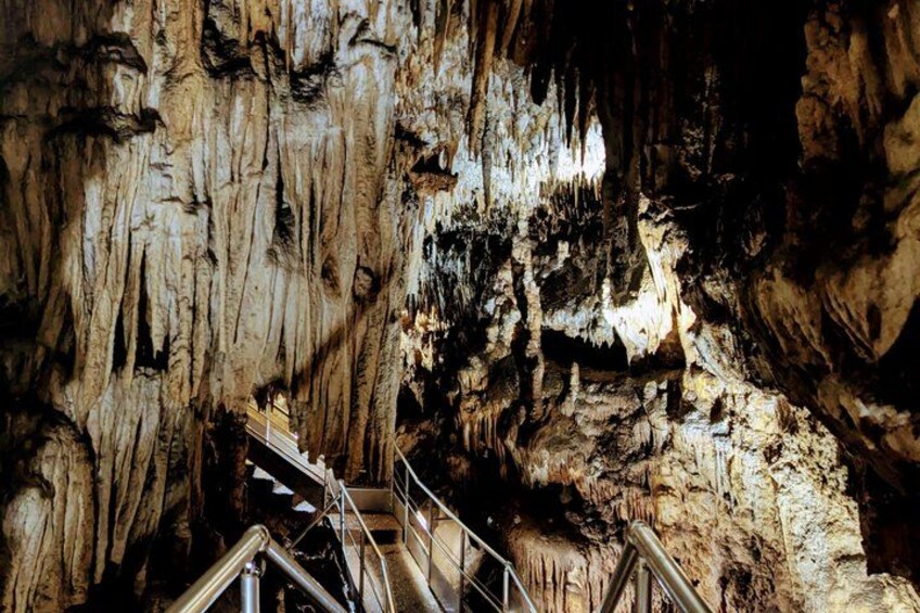 A cave with stalactites and a metal staircase. 2