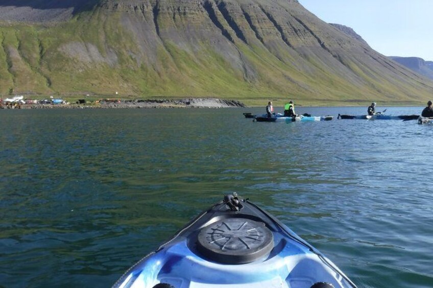A kayak on calm water with a mountainous landscape in the background. 3