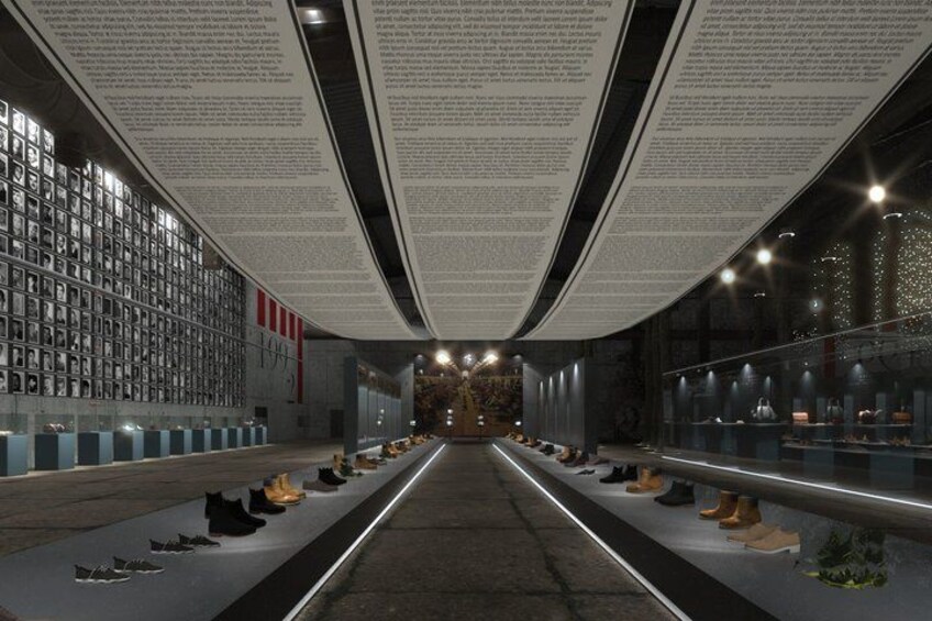 An indoor exhibition space with a central walkway, glass display cases, and informational panels. 2
