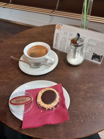 A table with a cup of coffee, a glass of milk, and a plate with a dessert. 4