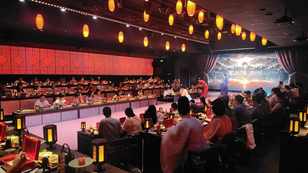 A traditional Chinese opera performance with an audience seated in a dimly lit theater. 1