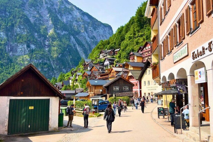 A mountain village with traditional wooden houses, a restaurant, and a paved street. 5