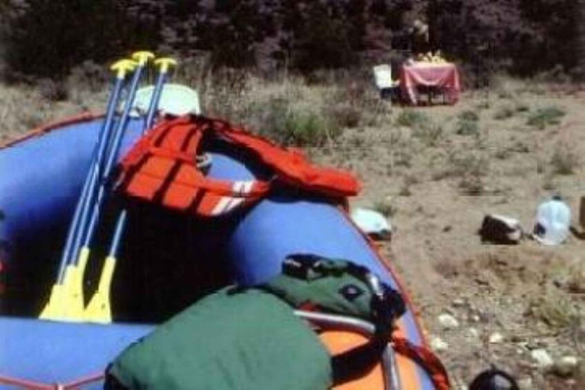 Un radeau bleu avec un gilet de sauvetage rouge et un sac vert. 1