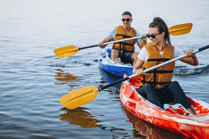 Two people kayaking on calm water. 1